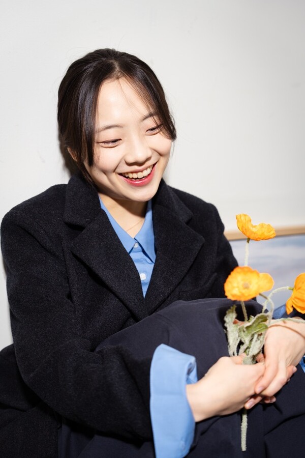 꽃을 들고 미소 짓는 환경 활동가 홍다경